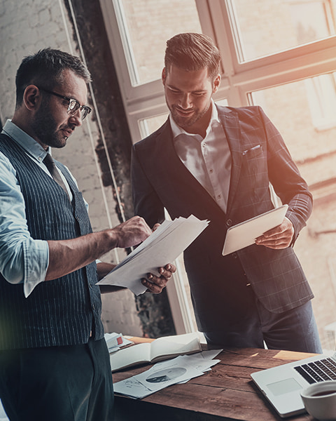 Two well-dressed businessmen looking at documents