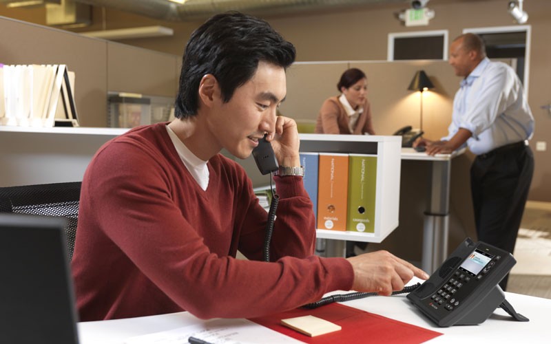 Businessman using desk phone