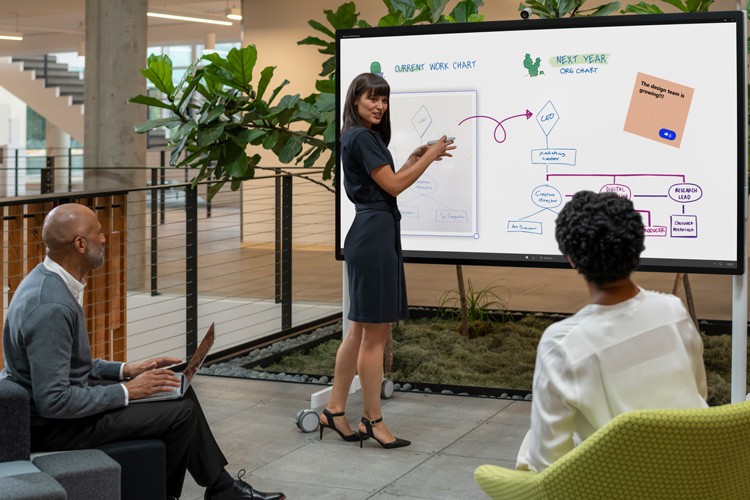 Woman showing chart on Surface Hub 2S 85"