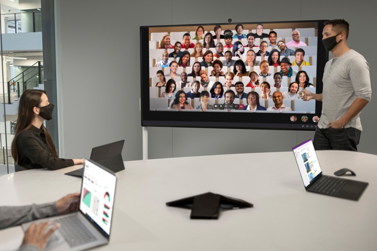 Man and Woman wearing masks working with Surface Hub 2S 85"
