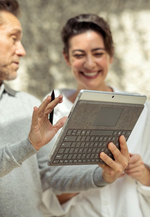 Surface Pro 9 Zwei Kollegen arbeiten an einem Surface Pro 9 im Park