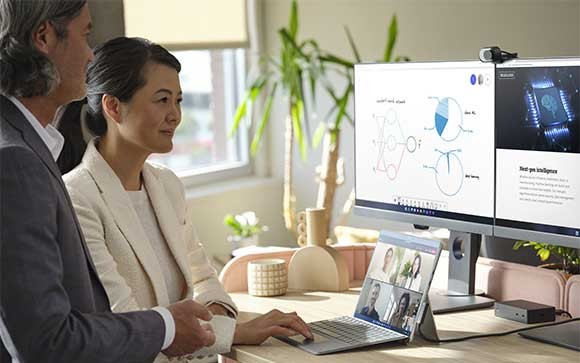 Twee collega's werken op een Surface Pro 8 met externe monitoren